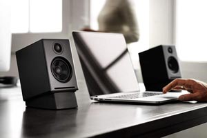 quiet speakers on a table with a laptop