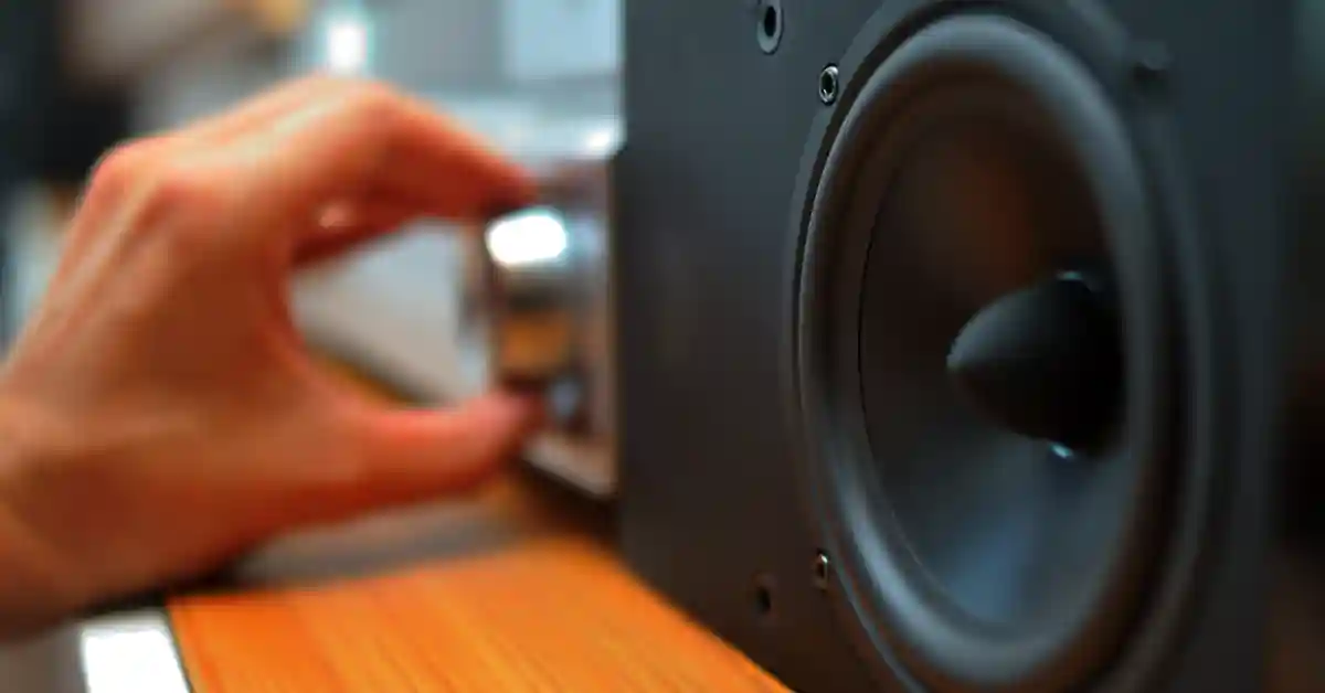 Person making subwoofer louder using volume dial